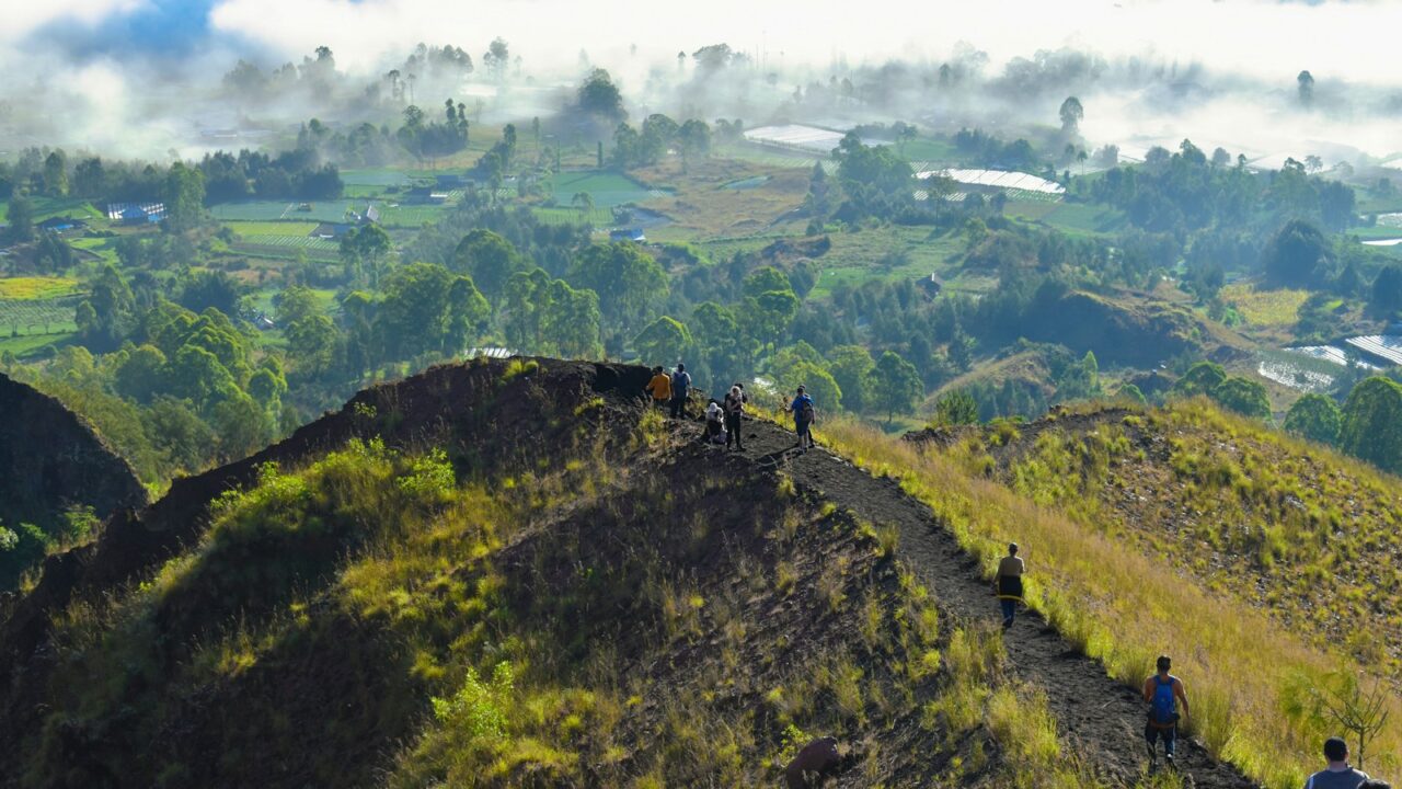 a group of people walking up the side of a mountain