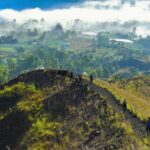 a group of people walking up the side of a mountain