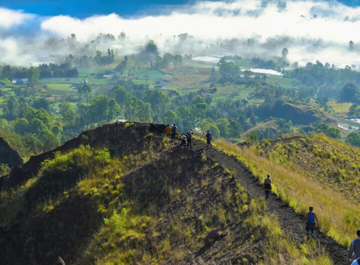 a group of people walking up the side of a mountain