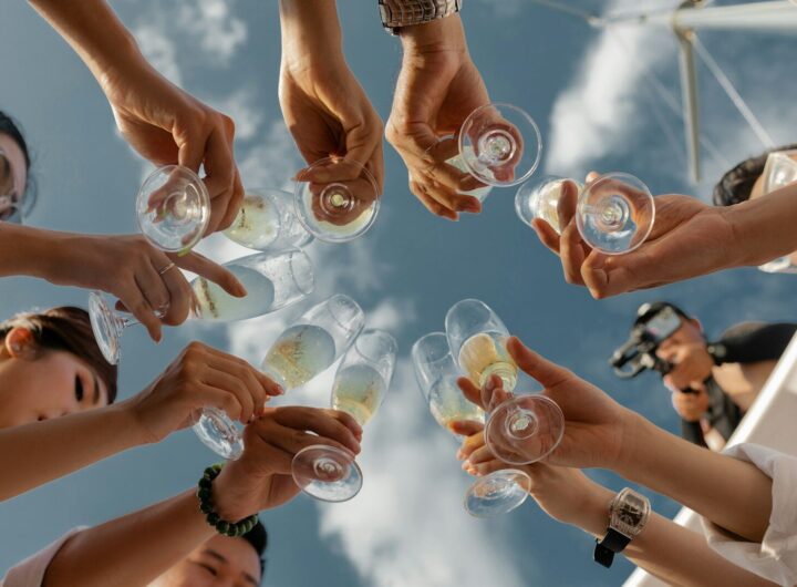 people holding clear glass bottles during daytime